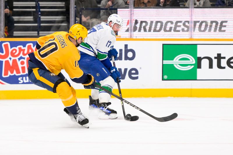 Jan 29, 2025; Nashville, Tennessee, USA;  Vancouver Canucks defenseman Filip Hronek (17) and Nashville Predators center Colton Sissons (10) battle for the puck during the third period at Bridgestone Arena. Mandatory Credit: Steve Roberts-Imagn Images