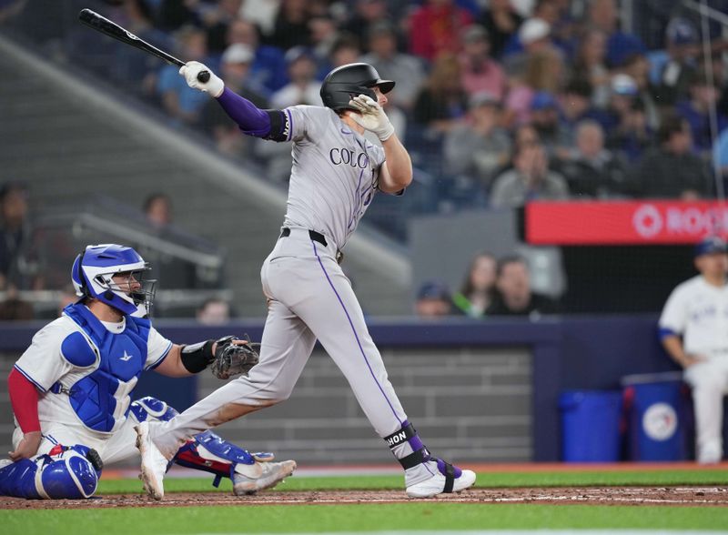 Apr 12, 2024; Toronto, Ontario, CAN; Colorado Rockies third baseman Ryan McMahon (24) hits a single against the Toronto Blue Jays during the fourth inning at Rogers Centre. Mandatory Credit: Nick Turchiaro-USA TODAY Sports