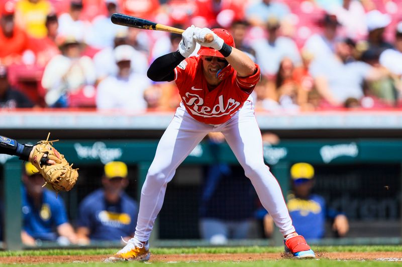 Aug 17, 2025; Cincinnati, Ohio, USA; Cincinnati Reds first baseman Spencer Steer (7) dodges a wild pitch in the first inning against the Milwaukee Brewers at Great American Ball Park. Mandatory Credit: Katie Stratman-Imagn Images