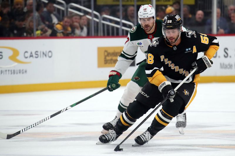 Oct 29, 2024; Pittsburgh, Pennsylvania, USA; Pittsburgh Penguins defenseman Kris Letang (58) skates with the puck ahead of Minnesota Wild left wing Marcus Foligno (17) during the second period at PPG Paints Arena. Mandatory Credit: Charles LeClaire-Imagn Images