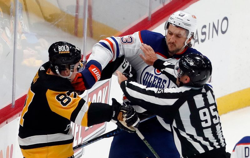 Mar 10, 2024; Pittsburgh, Pennsylvania, USA;  Pittsburgh Penguins center Sidney Crosby (87) and Edmonton Oilers defenseman Vincent Desharnais (73) are separated by linesman Jonny Murray (95) during the third period at PPG Paints Arena. The Oilers won 4-0. Mandatory Credit: Charles LeClaire-USA TODAY Sports