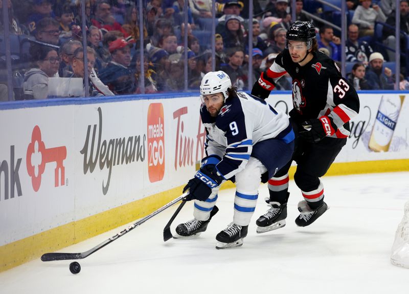 Mar 3, 2024; Buffalo, New York, USA;  Winnipeg Jets left wing Alex Iafallo (9) goes after a loose puck as Buffalo Sabres defenseman Ryan Johnson (33) defends during the third period at KeyBank Center. Mandatory Credit: Timothy T. Ludwig-USA TODAY Sports