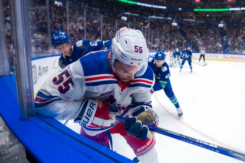 Nov 19, 2024; Vancouver, British Columbia, CAN; Vancouver Canucks defenseman Tyler Myers (57) checks New York Rangers defenseman Ryan Lindgren (55) during the first period at Rogers Arena. Mandatory Credit: Bob Frid-Imagn Images