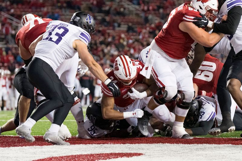 Nov 11, 2023; Madison, Wisconsin, USA;  Wisconsin Badgers running back Jackson Acker (34) scores a touchdown during the fourth quarter against the Northwestern Wildcats at Camp Randall Stadium. Mandatory Credit: Jeff Hanisch-USA TODAY Sports