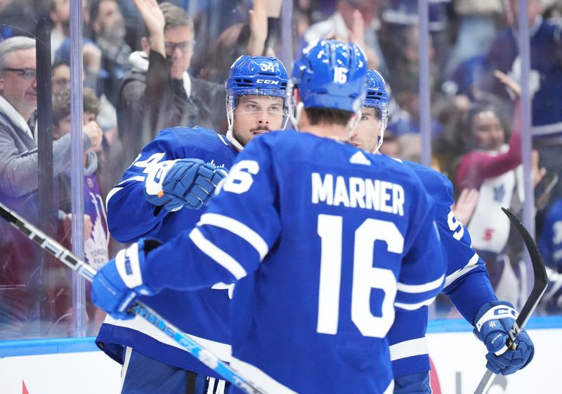 Oct 11, 2023; Toronto, Ontario, CAN; Toronto Maple Leafs center Auston Matthews (34) scores his third goal of the game and celebrates with right wing Mitchell Marner (16) and center John Tavares (91) against the Montreal Canadiens during the third period at Scotiabank Arena. Mandatory Credit: Nick Turchiaro-USA TODAY Sports