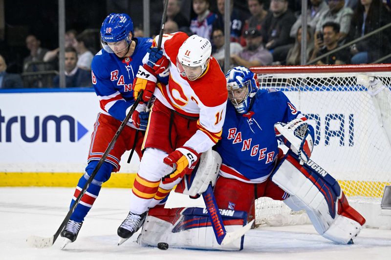 Mar 10, 2026; New York, New York, USA;  Calgary Flames center Mikael Backlund (11) falls over New York Rangers goaltender Jonathan Quick (32) defended by New York Rangers defenseman Urho Vaakanainen (18) during the second period at Madison Square Garden. Mandatory Credit: Dennis Schneidler-Imagn Images