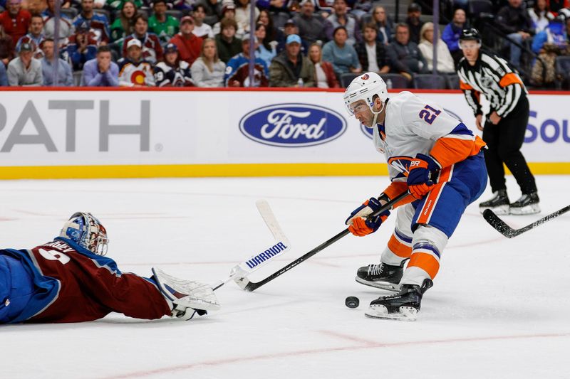 Oct 14, 2024; Denver, Colorado, USA; Colorado Avalanche goaltender Alexandar Georgiev (40) dives for the puck against New York Islanders center Kyle Palmieri (21) in the first period at Ball Arena. Mandatory Credit: Isaiah J. Downing-Imagn Images