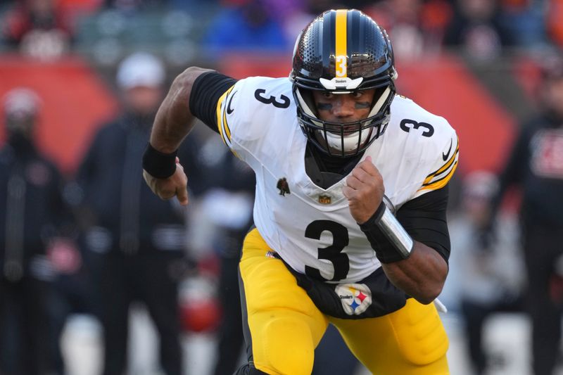 Pittsburgh Steelers quarterback Russell Wilson runs after handing the ball off during the first half of an NFL football game against the Cincinnati Bengals, Sunday, Dec. 1, 2024, in Cincinnati. (AP Photo/Kareem Elgazzar)