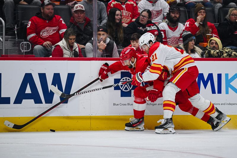 Nov 27, 2024; Detroit, Michigan, USA; Detroit Red Wings center Joe Veleno (90) brings the puck up ice against Calgary Flames center Kevin Rooney (21) during the second period at Little Caesars Arena. Mandatory Credit: Tim Fuller-Imagn Images