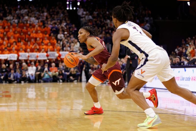 Feb 1, 2025; Charlottesville, Virginia, USA; Images Virginia Tech Hokies guard Ben Hammond (11) dribbles the ball as Virginia Cavaliers guard Dai Dai Ames (7) defends during the first half at John Paul Jones Arena. Mandatory Credit: Amber Searls-Imagn