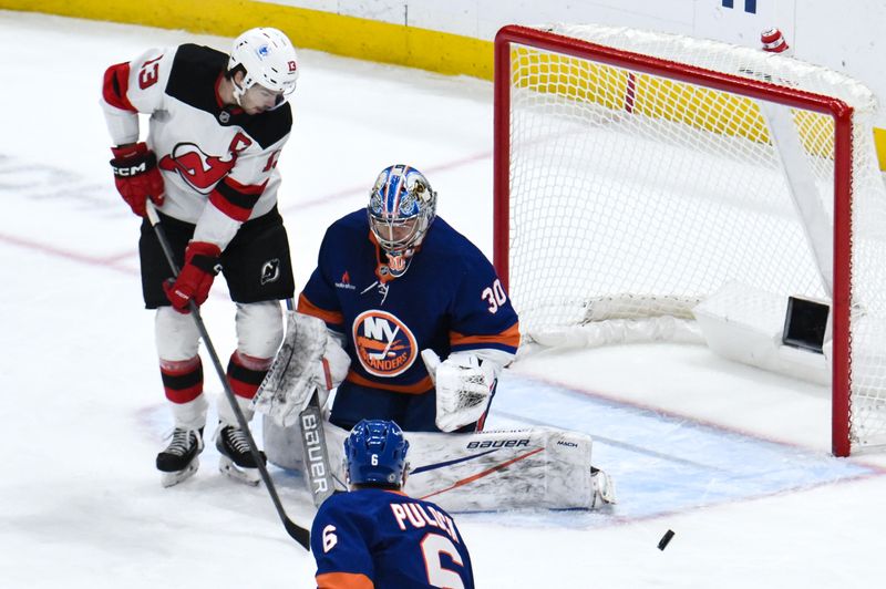 Nov 9, 2024; Elmont, New York, USA; New York Islanders goaltender Ilya Sorokin (30) makes a save against New Jersey Devils center Nico Hischier (13) during the first period at UBS Arena. Mandatory Credit: John Jones-Imagn Images