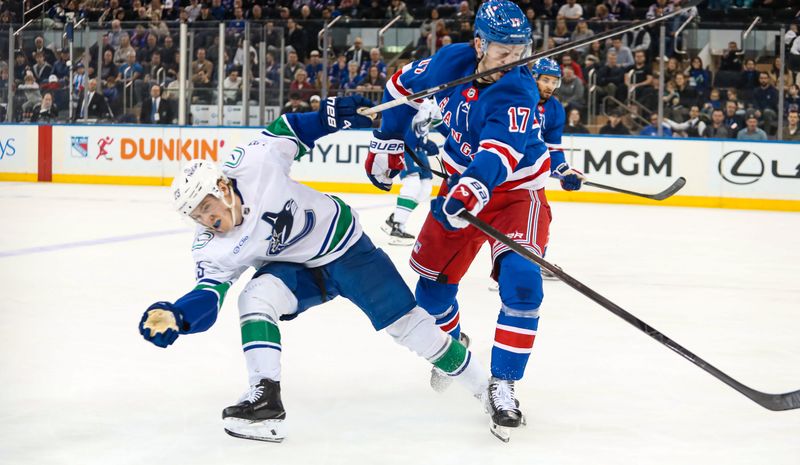Mar 22, 2025; New York, New York, USA; New York Rangers defenseman Will Borgen (17) shoves Vancouver Canucks right wing Jonathan Lekkerimaki (23) during the second period at Madison Square Garden. Mandatory Credit: Danny Wild-Imagn Images