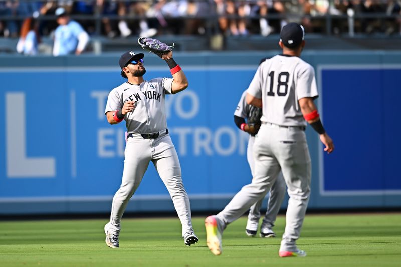 Jun 1, 2025; Los Angeles, California, USA; New York Yankees outfielder Jasson Domínguez (24) makes a catch with third baseman Oswald Peraza (18) against the Los Angeles Dodgers during the fourth inning at Dodger Stadium. Mandatory Credit: Jonathan Hui-Imagn Images