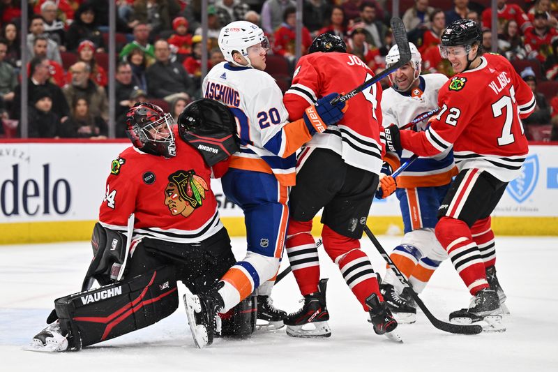 Jan 19, 2024; Chicago, Illinois, USA; Chicago Blackhawks defenseman Seth Jones (4) battles for position with New York Islanders forward Hudson Fasching (20) in front of goaltender Petr Mrazek (34) as the puck flies in during the second period at United Center. Mandatory Credit: Jamie Sabau-USA TODAY Sports