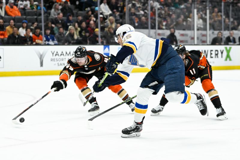 Mar 25, 2023; Anaheim, California, USA; St. Louis Blues center Jordan Kyrou (25) shoots whileAnaheim Ducks defenseman Colton White (45) defends during the second period at Honda Center. Mandatory Credit: Kelvin Kuo-USA TODAY Sports