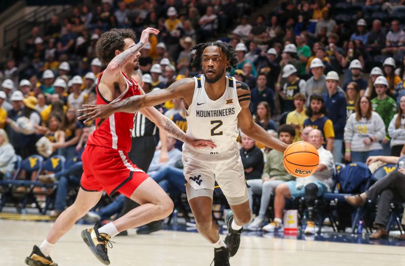 Mar 2, 2024; Morgantown, West Virginia, USA; West Virginia Mountaineers guard Kobe Johnson (2) drives against Texas Tech Red Raiders guard Pop Isaacs (2) during the second half at WVU Coliseum. Mandatory Credit: Ben Queen-USA TODAY Sports