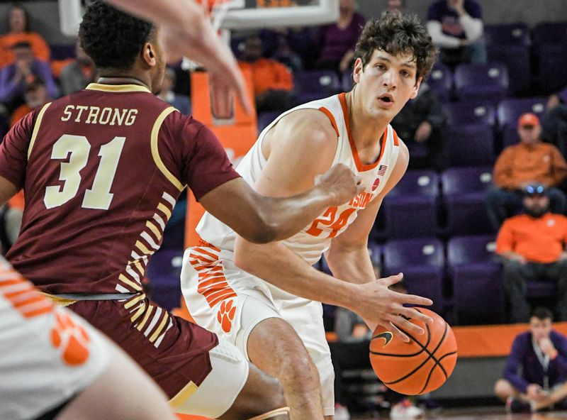 Jan 13, 2024; Clemson, South Carolina, USA; Clemson Tigers forward PJ Hall (24) passes the ball around Boston College Eagles forward Elijah Strong (31) during the first half at Littlejohn Coliseum. Mandatory Credit: Ken Ruinard-USA TODAY Sports