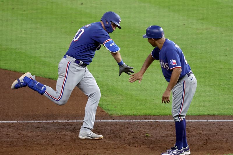 Oct 23, 2023; Houston, Texas, USA; Texas Rangers first baseman Nathaniel Lowe (30) celebrates with third base coach Tony Beasley (27) after a home run during the sixth inning of game seven in the ALCS against the Houston Astros for the 2023 MLB playoffs at Minute Maid Park. Mandatory Credit: Troy Taormina-USA TODAY Sports