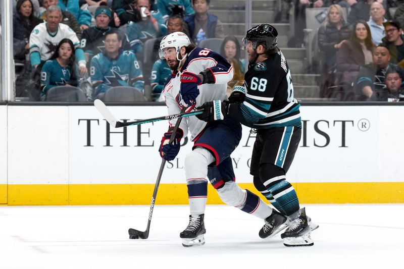 Feb 17, 2024; San Jose, California, USA; Columbus Blue Jackets right wing Kirill Marchenko (left) shoots against San Jose Sharks center Mike Hoffman (68) during the first period at SAP Center at San Jose. Mandatory Credit: Darren Yamashita-USA TODAY Sports