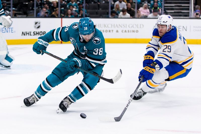 Nov 23, 2024; San Jose, California, USA;  San Jose Sharks defenseman Mario Ferraro (38) and Buffalo Sabres left wing Beck Malenstyn (29) battle for possession during the first period at SAP Center in San Jose. Mandatory Credit: John Hefti-Imagn Images