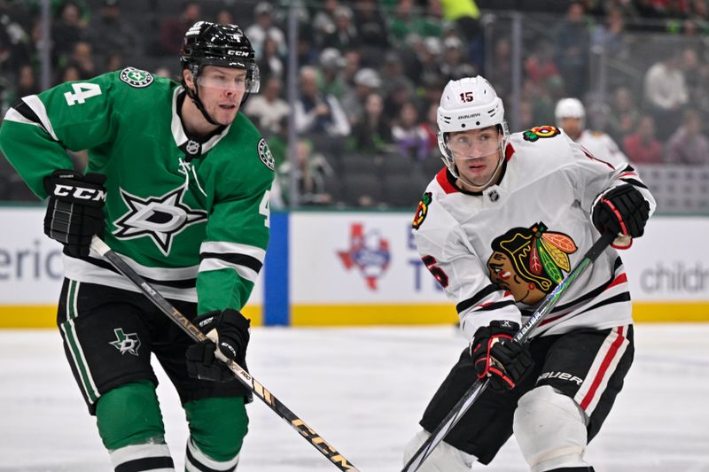 Nov 7, 2024; Dallas, Texas, USA; Dallas Stars defenseman Miro Heiskanen (4) and Chicago Blackhawks center Craig Smith (15) look for the puck at center ice during the first period at the American Airlines Center. Mandatory Credit: Jerome Miron-Imagn Images