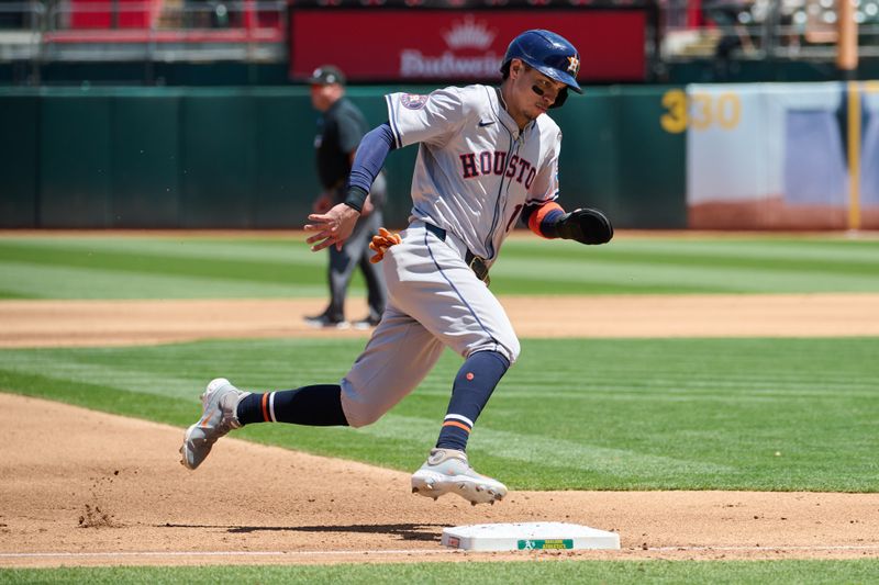 May 26, 2024; Oakland, California, USA; Houston Astros outfielder Mauricio Dubon (14) runs from third base to home to score a run against the Oakland Athletics during the fourth inning at Oakland-Alameda County Coliseum. Mandatory Credit: Robert Edwards-USA TODAY Sports