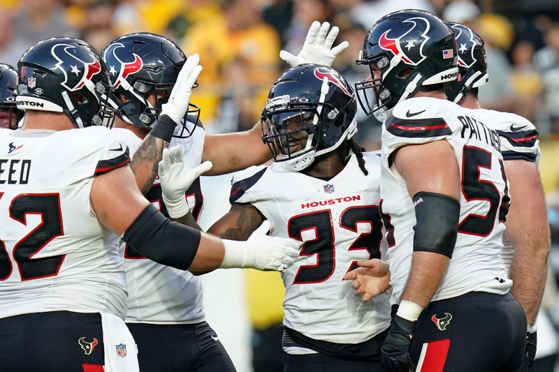 Houston Texans running back Dare Ogunbowale (33) celebrates his touchdown during the second half of an NFL exhibition football game against the Pittsburgh Steelers Friday, Aug. 9, 2024, in Pittsburgh. (AP Photo/Matt Freed)