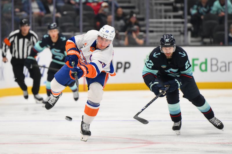 Nov 16, 2024; Seattle, Washington, USA; New York Islanders center Brock Nelson (29) passes the puck while defended by Seattle Kraken right wing Oliver Bjorkstrand (22) during the second period at Climate Pledge Arena. Mandatory Credit: Steven Bisig-Imagn Images