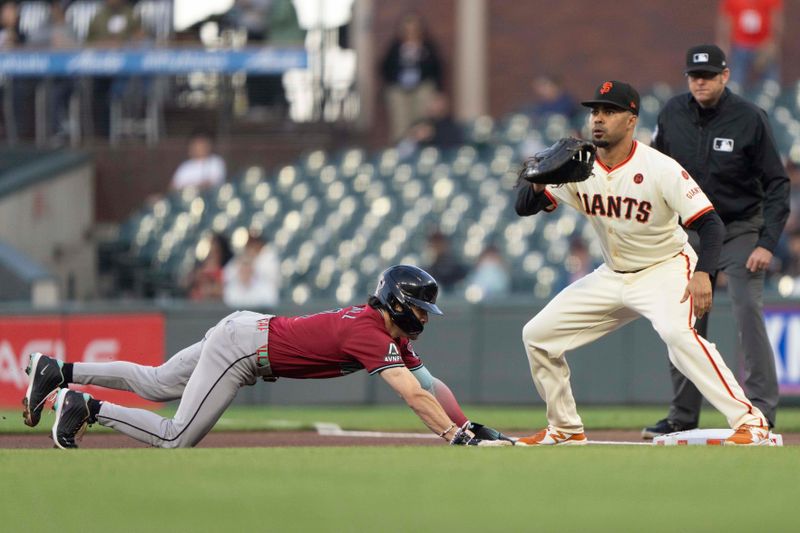 Sep 4, 2024; San Francisco, California, USA;  Arizona Diamondbacks outfielder Corbin Carroll (7) dives back to first base during the first inning against San Francisco Giants first base LaMonte Wade Jr. (31) at Oracle Park. Mandatory Credit: Stan Szeto-Imagn Images