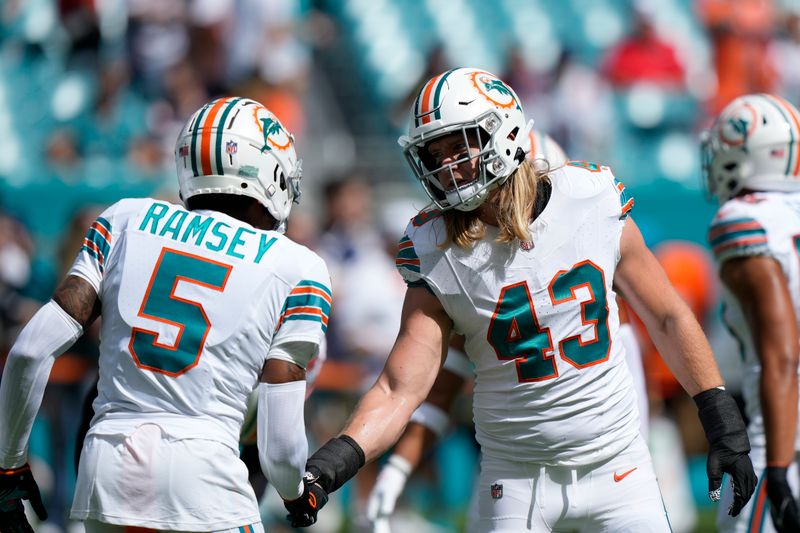 Miami Dolphins cornerback Jalen Ramsey (5) and linebacker Andrew Van Ginkel (43) greet each other as they warm up before the start of an NFL football game against the New England Patriots, Monday, Sunday, Oct. 29, 2023 in Miami Gardens, Fla. (AP Photo/Wilfredo Lee)