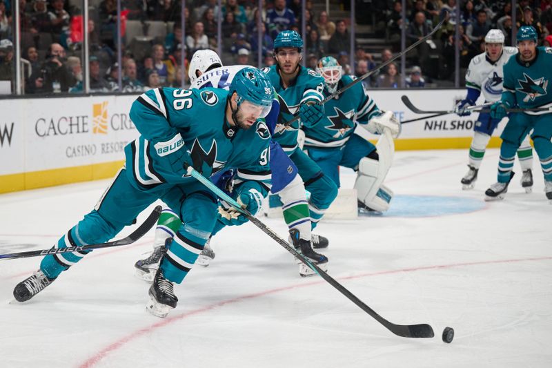 Nov 2, 2024; San Jose, California, USA; San Jose Sharks defenseman Jake Walman (96) plays the puck against the Vancouver Canucks during the first period at SAP Center at San Jose. Mandatory Credit: Robert Edwards-Imagn Images