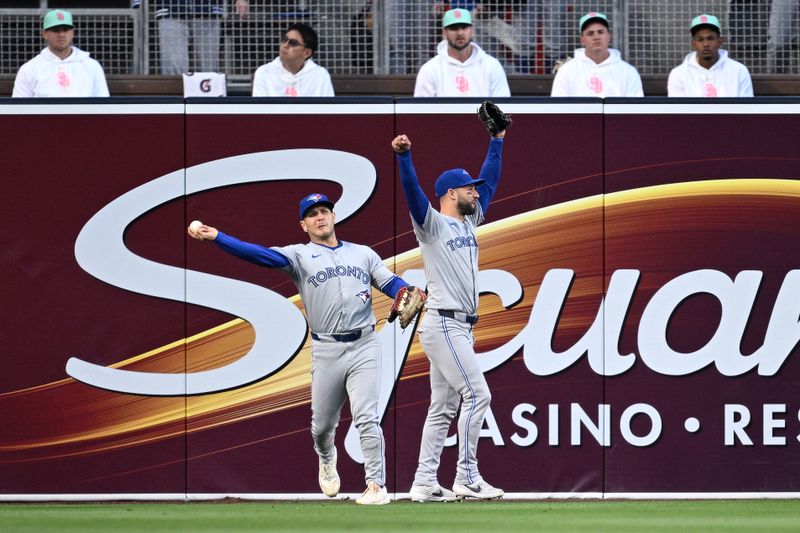 Apr 19, 2024; San Diego, California, USA; Toronto Blue Jays center fielder Kevin Kiermaier (center) celebrates after a catch by left fielder Daulton Varsho (left) on a ball hit by San Diego Padres second baseman Xander Bogaerts (not pictured) during the first inning at Petco Park. Mandatory Credit: Orlando Ramirez-USA TODAY Sports 