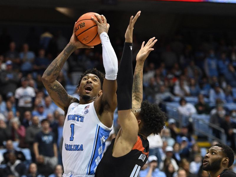 Feb 13, 2023; Chapel Hill, North Carolina, USA; North Carolina Tar Heels forward Leaky Black (1) shoots as Miami (Fl) Hurricanes guard Jordan Miller (11) defends in the second half at Dean E. Smith Center. Mandatory Credit: Bob Donnan-USA TODAY Sports