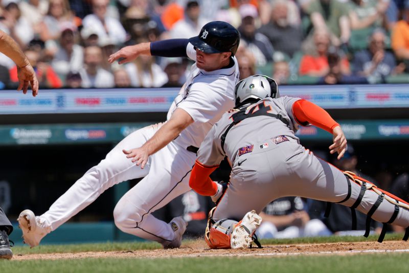 May 26, 2025; Detroit, Michigan, USA;  Detroit Tigers second base Colt Keith (33) slides in safe at home ahead on the tag by San Francisco Giants catcher Patrick Bailey (14) in the fourth inning at Comerica Park. Mandatory Credit: Rick Osentoski-Imagn Images