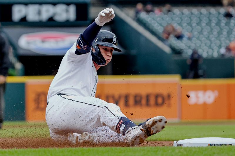 Jul 10, 2024; Detroit, Michigan, USA;  Detroit Tigers second baseman Colt Keith (33) slides into third after hitting a RBI triple in the first inning against the Cleveland Guardians at Comerica Park. Mandatory Credit: Rick Osentoski-USA TODAY Sports