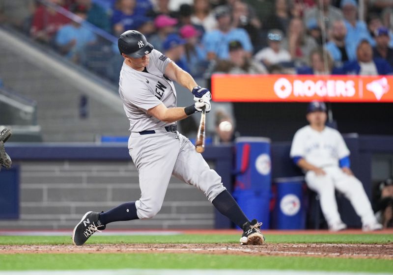 Jun 30, 2024; Toronto, Ontario, CAN; New York Yankees third baseman DJ LeMahieu (26) hits an RBI double against the Toronto Blue Jays during the fifth inning at Rogers Centre. Mandatory Credit: Nick Turchiaro-USA TODAY Sports