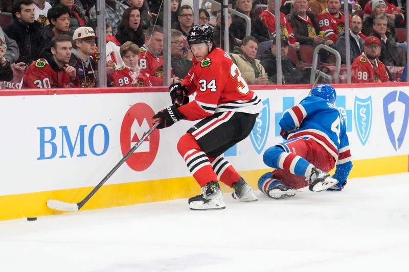Dec 10, 2025; Chicago, Illinois, USA; New York Rangers defenseman Braden Schneider (4) and Chicago Blackhawks center Colton Dach (34) go for the puck during the second period at United Center. Mandatory Credit: David Banks-Imagn Images