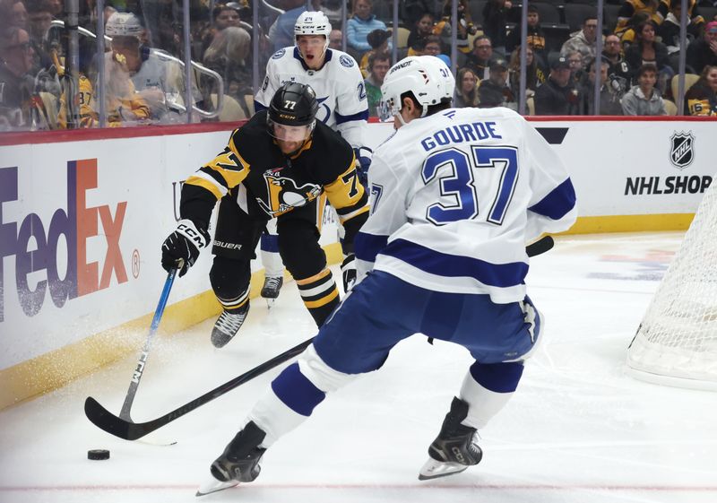 Jan 13, 2026; Pittsburgh, Pennsylvania, USA;  Pittsburgh Penguins defenseman Brett Kulak (77) moves the puck against Tampa Bay Lightning center Yanni Gourde (37) during the first period at PPG Paints Arena. Mandatory Credit: Charles LeClaire-Imagn Images