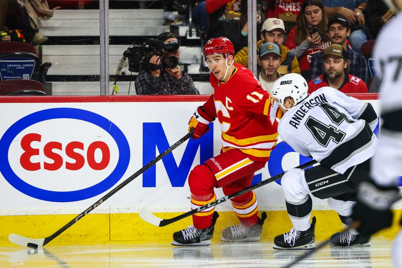 Nov 11, 2024; Calgary, Alberta, CAN; Calgary Flames center Mikael Backlund (11) controls the puck against Los Angeles Kings defenseman Mikey Anderson (44) during the second period at Scotiabank Saddledome. Mandatory Credit: Sergei Belski-Imagn Images