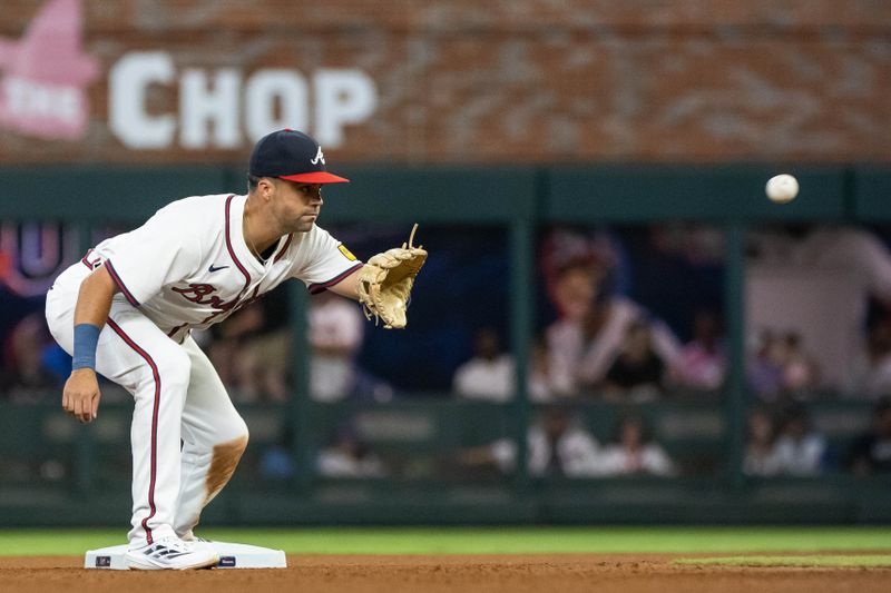 Aug 22, 2024; Cumberland, Georgia, USA; Atlanta Braves outfielder Whit Merrifield (15) catches the ball in between innings against Philadelphia Phillies during the sixth inning at Truist Park. Mandatory Credit: Jordan Godfree-USA TODAY Sports