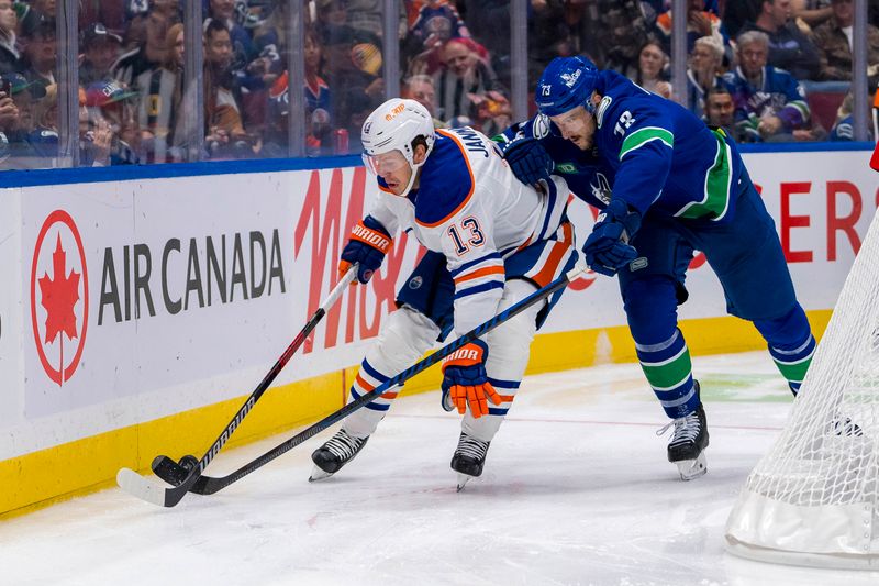 Oct 4, 2024; Vancouver, British Columbia, CAN; Vancouver Canucks defenseman Vincent Desharnais (73) stick checks Edmonton Oilers forward Mattias Janmark (13) during the second period at Rogers Arena. Mandatory Credit: Bob Frid-Imagn Images