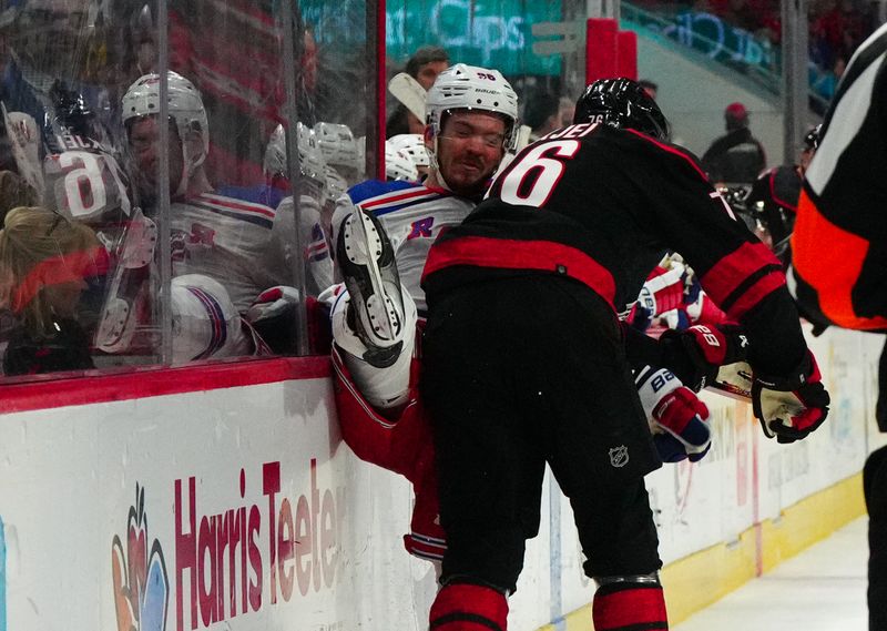 Mar 12, 2024; Raleigh, North Carolina, USA; Carolina Hurricanes defenseman Brady Skjei (76) checks New York Rangers center Jack Roslovic (96) during the second period at PNC Arena. Mandatory Credit: James Guillory-USA TODAY Sports