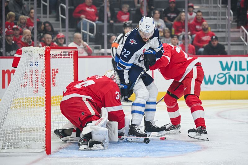 Oct 30, 2024; Detroit, Michigan, USA; Detroit Red Wings goaltender Alex Lyon (34) makes a save as defenseman Albert Johansson (20) and Winnipeg Jets center Mason Appleton (22) battle for position during the first period at Little Caesars Arena. Mandatory Credit: Tim Fuller-Imagn Images