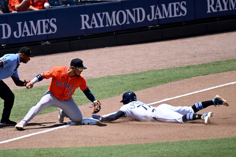 May 21, 2025; St. Petersburg, Florida, USA; Tampa Bay Rays shortstop Jose Caballero (77) steals third base as Houston Astros third baseman Isaac Paredes (15) attempts the tag  in the fifth inning  at George M. Steinbrenner Field. Mandatory Credit: Jonathan Dyer-Imagn Images