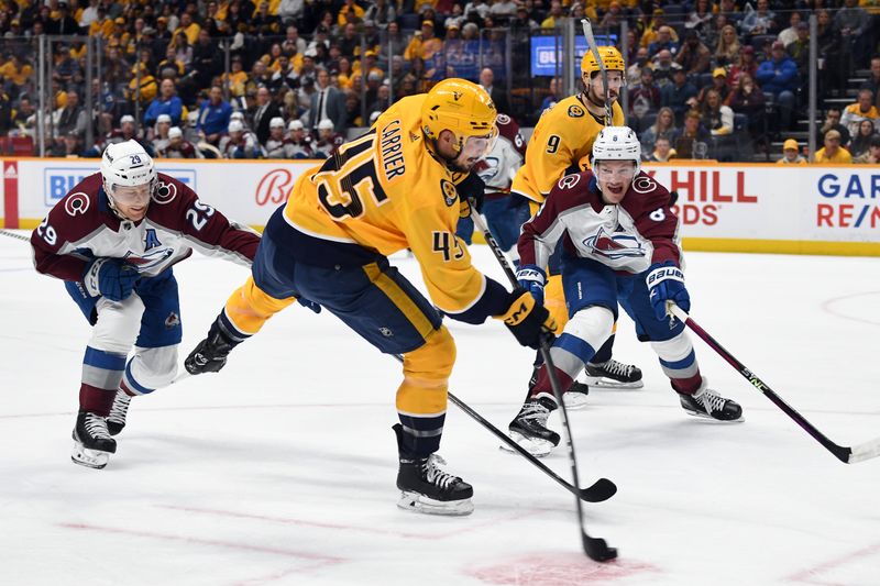 Mar 2, 2024; Nashville, Tennessee, USA; Nashville Predators defenseman Alexandre Carrier (45) shoots the puck during the first period against the Colorado Avalanche at Bridgestone Arena. Mandatory Credit: Christopher Hanewinckel-USA TODAY Sports