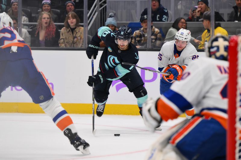 Nov 16, 2023; Seattle, Washington, USA; Seattle Kraken center Matty Beniers (10) plays the puck past New York Islanders defenseman Sebastian Aho (25) during the third period at Climate Pledge Arena. Mandatory Credit: Steven Bisig-USA TODAY Sports