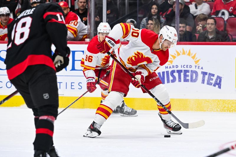 Nov 25, 2024; Ottawa, Ontario, CAN; Calgary Flames center Jonathan Huberdeau (10) plays the puck against the Ottawa Senators during the second period at Canadian Tire Centre. Mandatory Credit: David Kirouac-Imagn Images