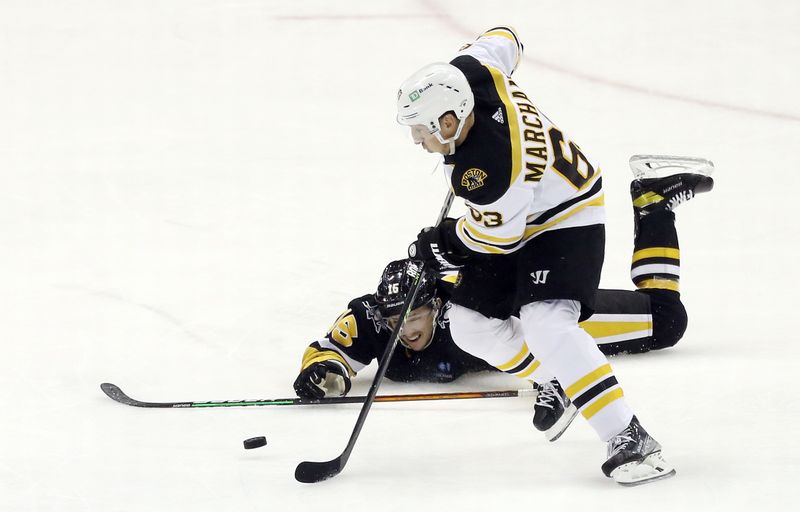 Nov 1, 2022; Pittsburgh, Pennsylvania, USA;  Pittsburgh Penguins right wing Josh Archibald (15) attempts to defend Boston Bruins left wing Brad Marchand (63) while prone on the ice during the second period at PPG Paints Arena. Mandatory Credit: Charles LeClaire-USA TODAY Sports