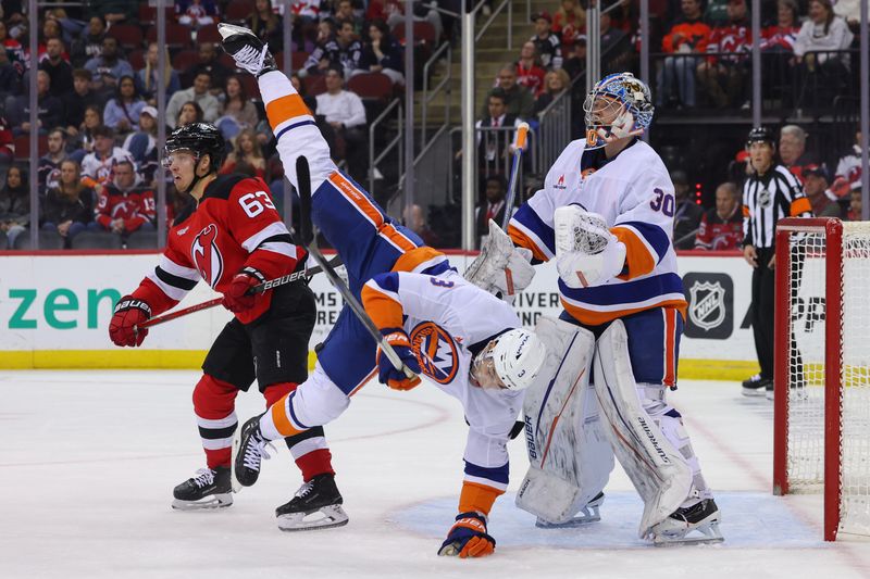 Oct 25, 2024; Newark, New Jersey, USA; New Jersey Devils left wing Jesper Bratt (63) interferes with New York Islanders defenseman Adam Pelech (3) during the second period at Prudential Center. Mandatory Credit: Ed Mulholland-Imagn Images