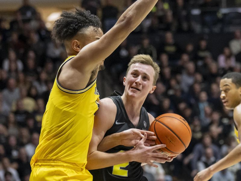 Jan 23, 2024; West Lafayette, Indiana, USA; Purdue Boilermakers guard Fletcher Loyer (2) loses control of the ball driving toward the basket against Michigan Wolverines forward Terrance Williams II (5) during the second half at Mackey Arena. Mandatory Credit: Marc Lebryk-USA TODAY Sports